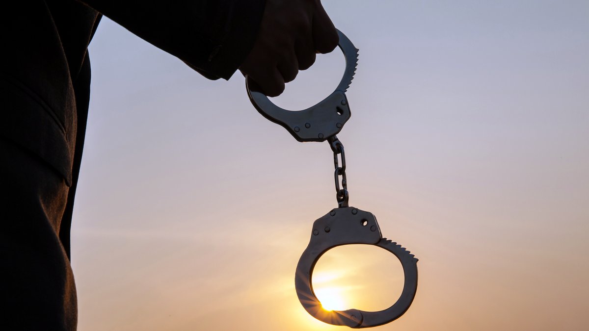 JESUS DELIVERED US FROM BONDAGE TO THE LAW::MAN HOLDING HANDCUFFS AFTER RELEASE © twinsterphoto | iStockPhoto.com