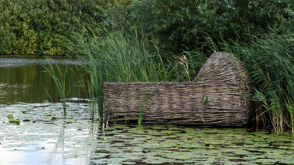 Floating wooden cradle basket in lily pads in Kinderdijk Netherlands © 14ktgold | Adobe