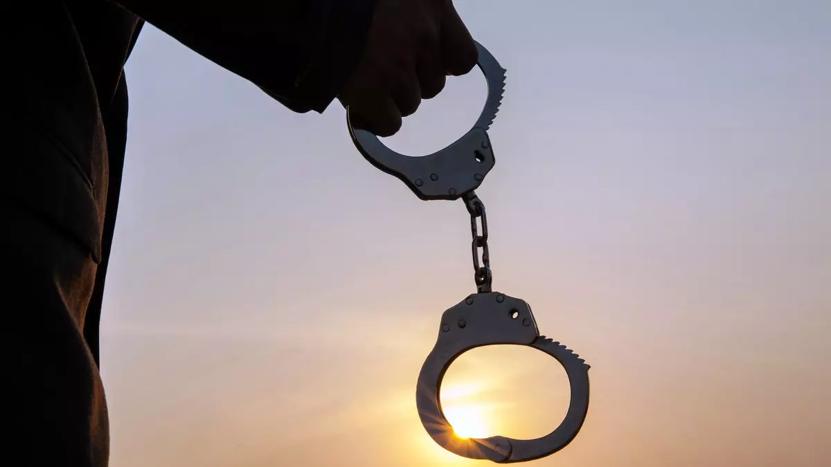 JESUS DELIVERED US FROM BONDAGE TO THE LAW::MAN HOLDING HANDCUFFS AFTER RELEASE © twinsterphoto | iStockPhoto.com
