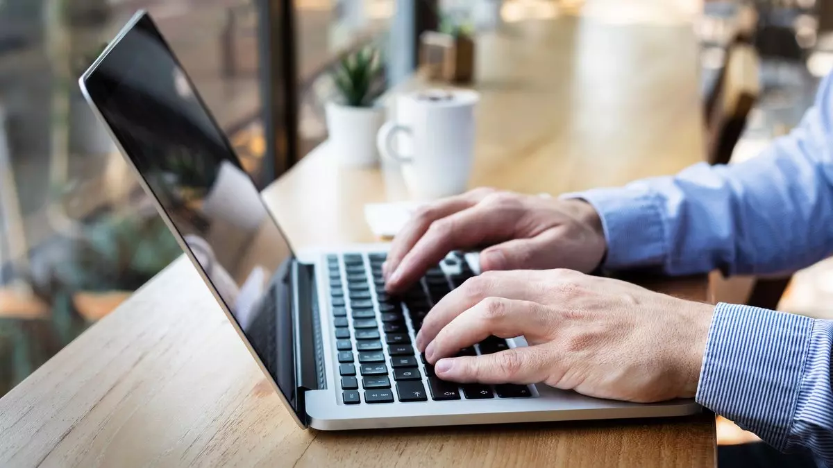 HANDS TYPING ON LAPTOP IN A CAFÉ © NicoElNino | iStockPhoto.com