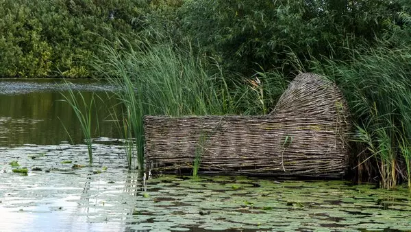 FLOATING WOODEN CRADLE BASKET IN LILY PADS © driftwood | Adobe Stock